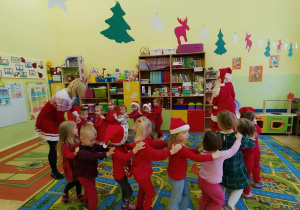 Dzieci tworzą pociąg za Mikołajem