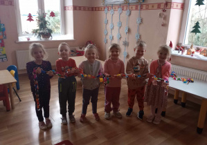 Dzieci z grupy ,,Słoneczka" pokazują wykonany łańcuch choinkowy.