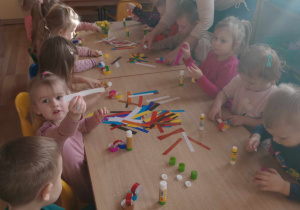 Dzieci sklejają paski tworząc łańcuch.