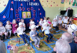 Chłopcy na krzesełkach prezentują taniec bałwanków.