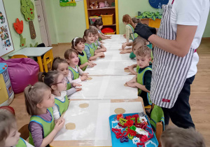 Pan Łukasz instruuje, jak wycinamy ciasteczka foremkami.