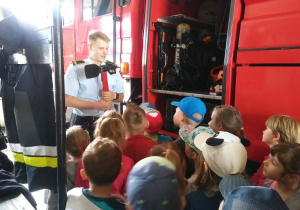 Dzieci oglądają wyposażenie wozu strażackiego.