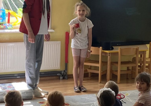 Dziewczynka trzyma w ręku magiczną kulkę, która nieoczekiwanie zmienia swoje miejsce położenia.