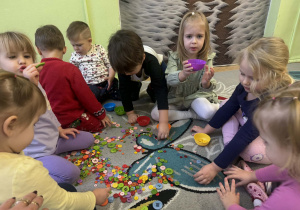 Dziewczynka trzyma w rękach miseczkę w kolorze fioletowym.