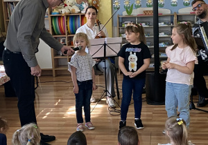 Na zdjęciu widzimy Pana Maćka i trzy dziewczynki, które przy muzyce operowej naśladują śpiew diwy.