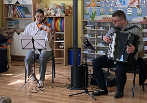 Pani gra na skrzypcach, a pan na akordeonie utwór Marsz turecki Mozarta.