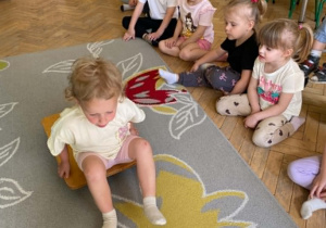 Dziewczynka podczas pokonywania toru przeszkód porusza się na desce na kółkach.