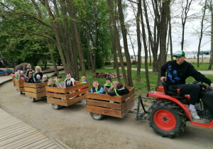Przedszkolaki z grupy „Misie” zwiedzają sad, jadąc wagonikami.