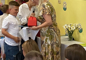Pani Dyrektor wręcza chłopcu dyplom i upominek.