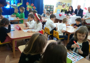 Dzieci rozwiązujące zadanie konkursowe - rozpoznawanie flag Polski i UE.