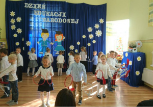 Grupa dzieci prezentuje układ taneczny z kółkami.