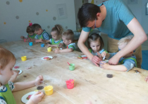 Dzieci dekorujące ciasteczka kolorowym lukrem.